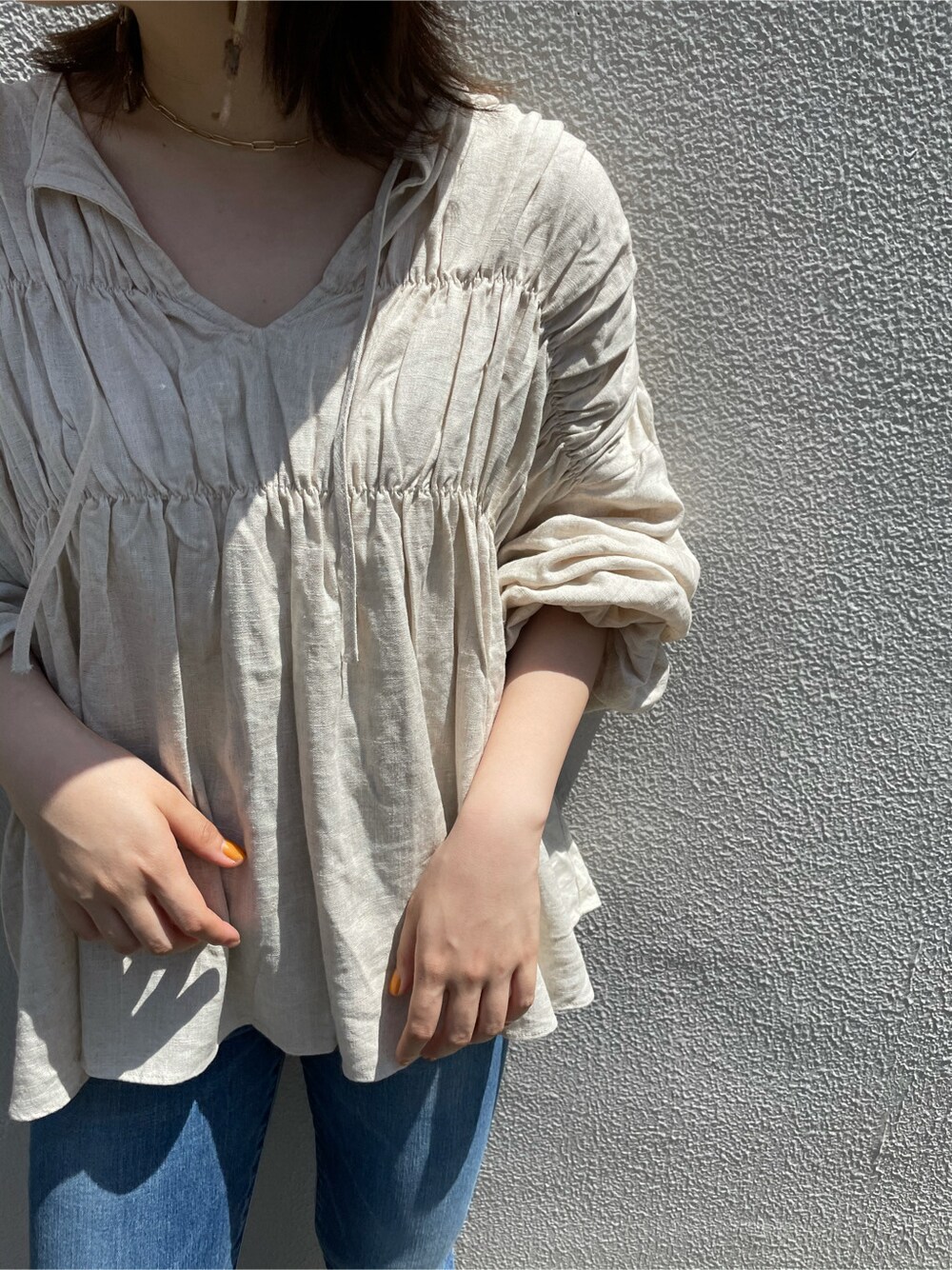 ホワイト系のシャツ/ブラウス、ブルー系のデニムパンツ、ブラウン系のピアス（両耳用）を着用したレディースの春コーディネートの2枚目の写真