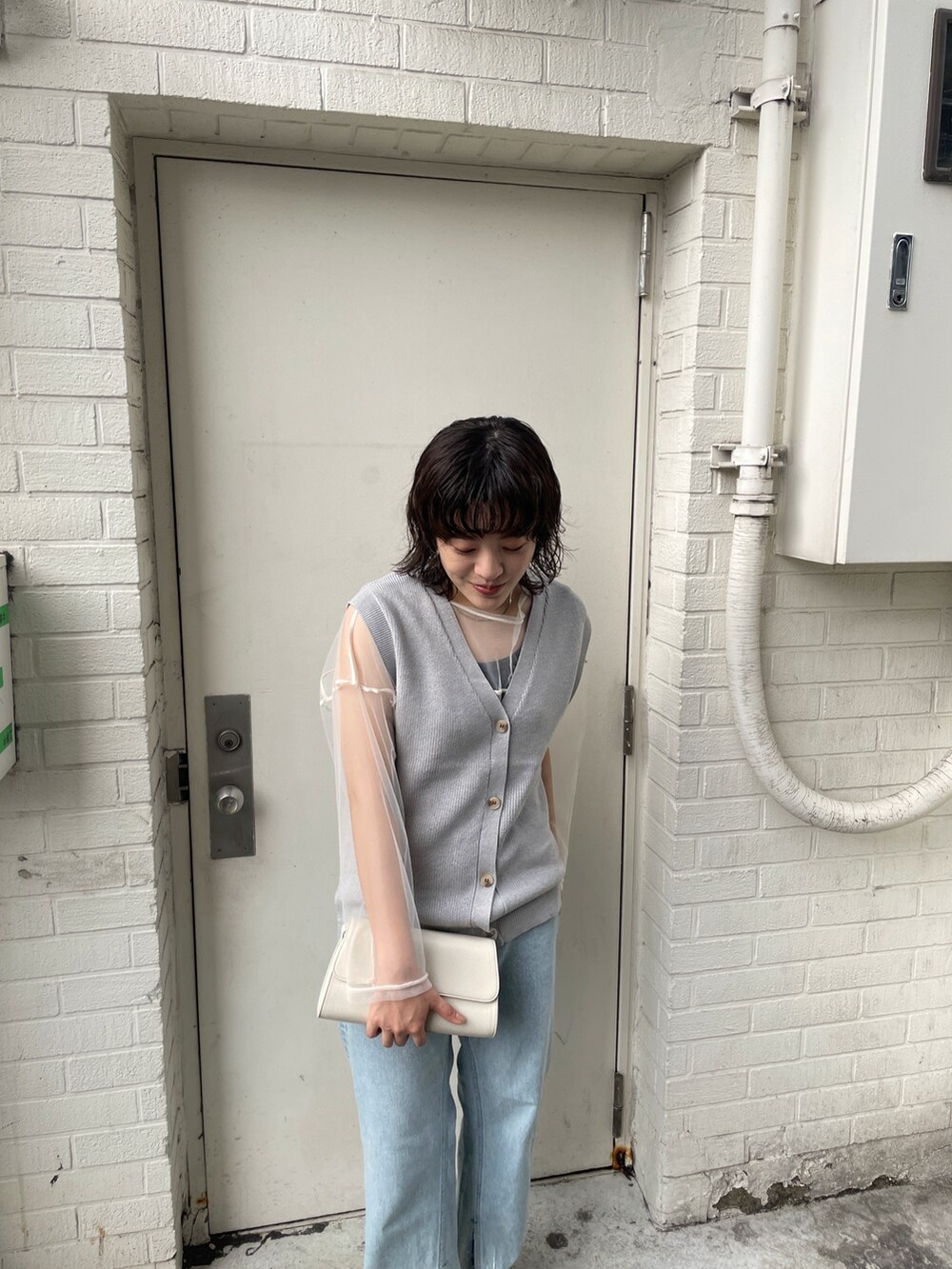 ブルー系のデニムパンツ、シルバー系のベスト、ホワイト系のTシャツ/カットソーを着用したレディースの夏コーディネートの4枚目の写真