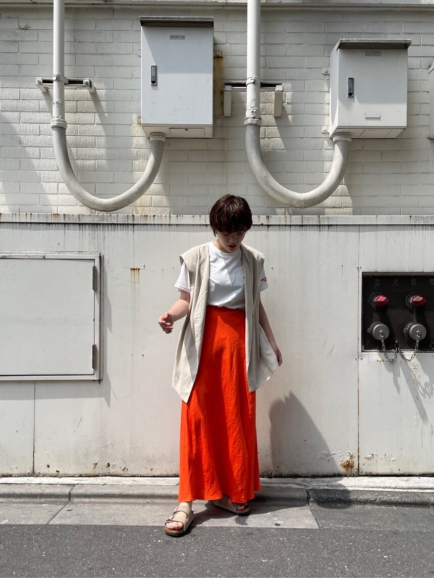 ホワイト系のベスト、ホワイト系のTシャツ/カットソー、オレンジ系のスカートを着用したレディースの夏コーディネートの4枚目の写真