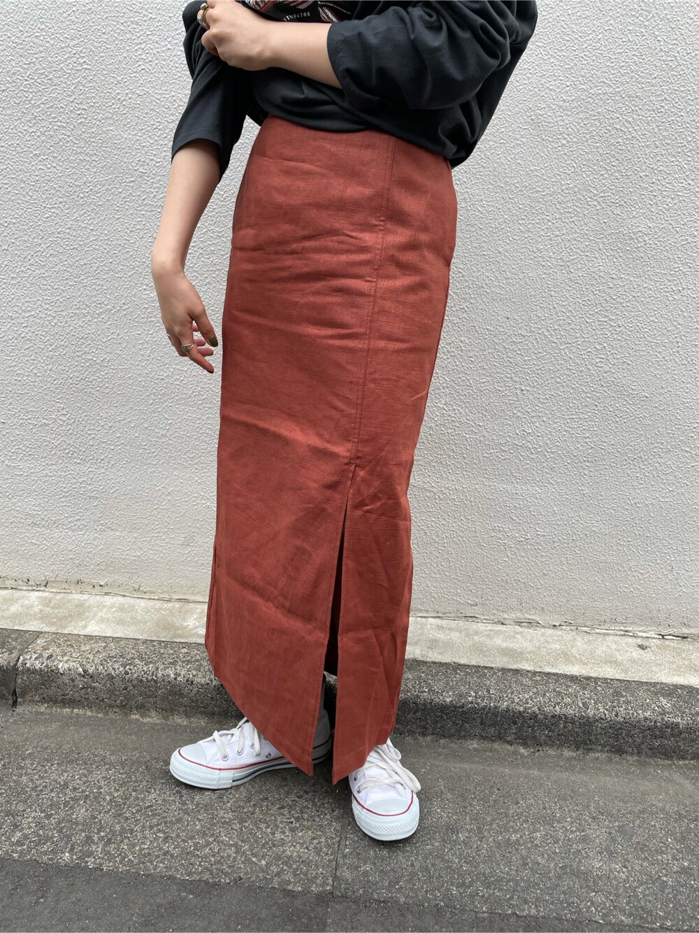 オレンジ系のスカートを着用したレディースの春コーディネートの3枚目の写真