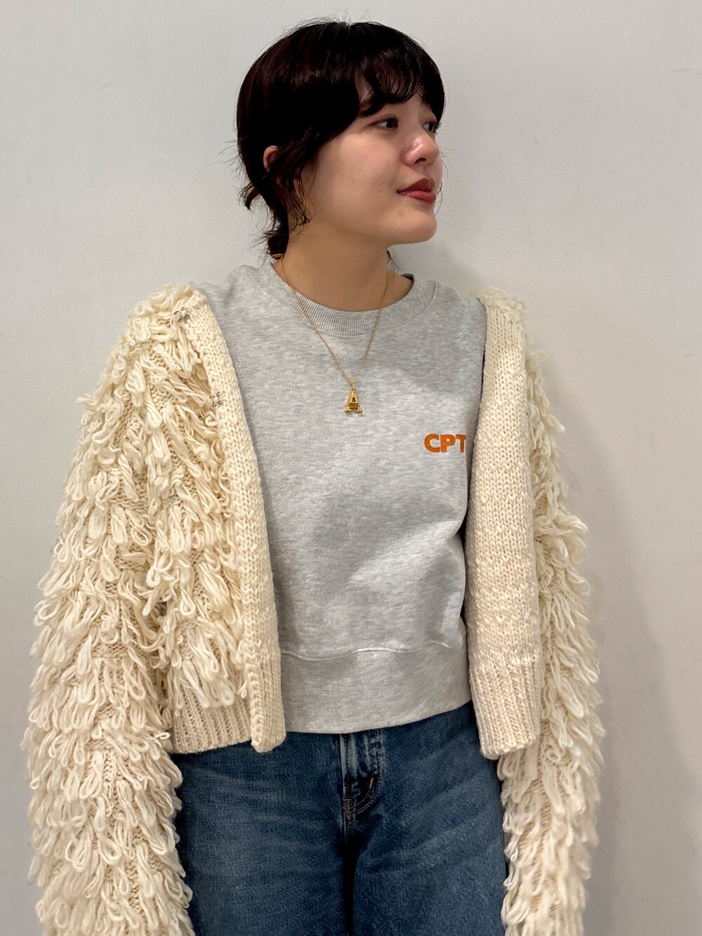 ホワイト系のカーディガン/ボレロ、ブルー系のデニムパンツ、グレー系のスウェットを着用したレディースの冬コーディネートの5枚目の写真