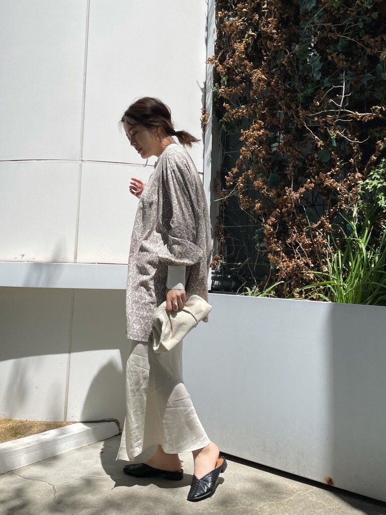 ホワイト系のスカート、ホワイト系のクラッチバッグを着用したレディースの春コーディネートの4枚目の写真