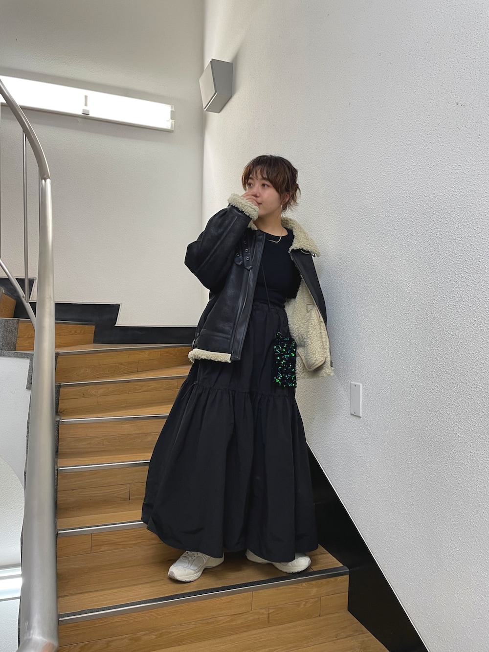 ブラック系のムートンコート、ブラック系のワンピースを着用したレディースの秋コーディネートの3枚目の写真