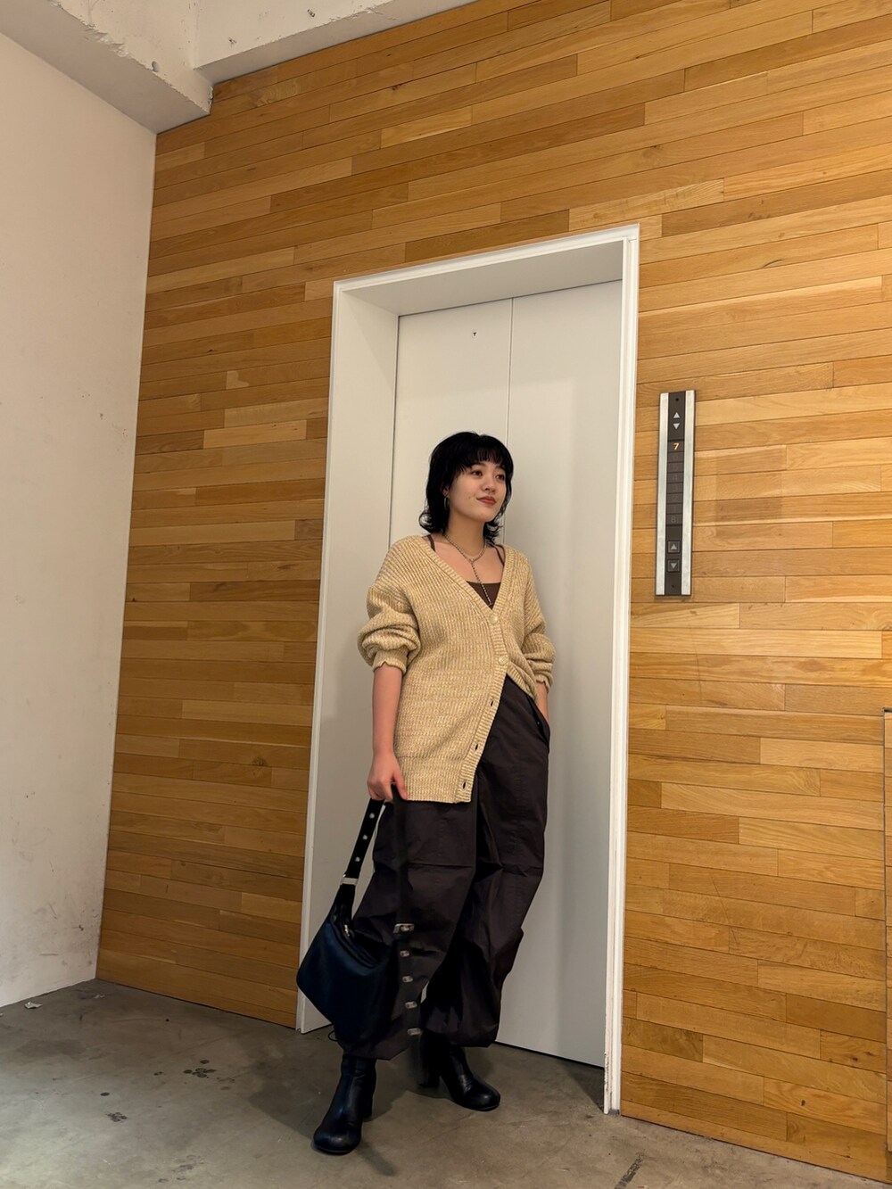 ベージュ系のカーディガン/ボレロ、グレー系のその他パンツ、ブラック系のショルダーバッグを着用したレディースの冬コーディネートの4枚目の写真