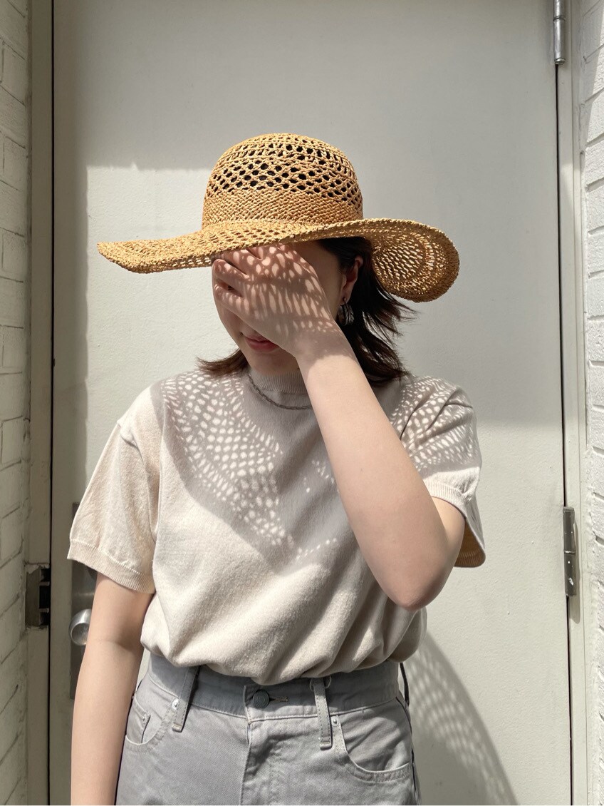 グレー系のデニムパンツ、ホワイト系のニット/セーター、ブラウン系のハットを着用したレディースの春コーディネートの5枚目の写真