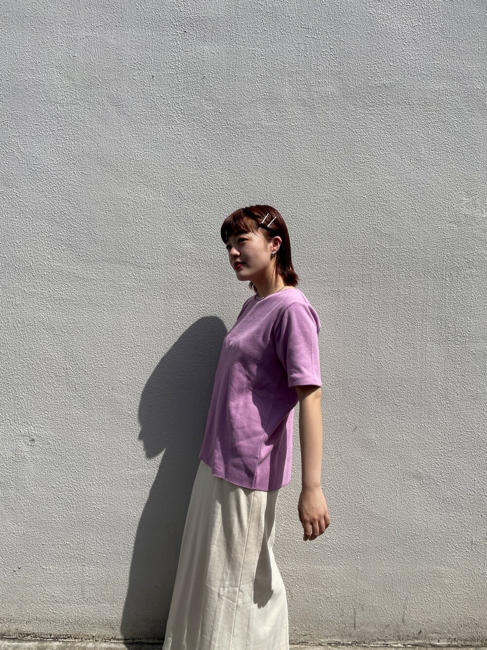 ホワイト系のスカート、パープル系のTシャツ/カットソー、ホワイト系のスニーカーを着用したレディースの春コーディネートの4枚目の写真