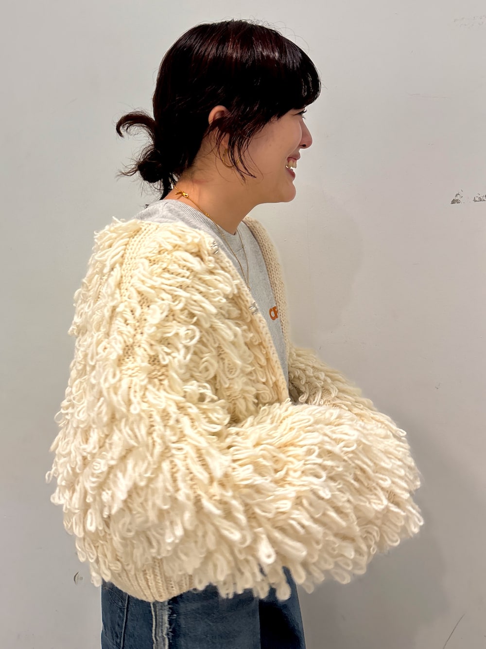 ホワイト系のカーディガン/ボレロ、ブルー系のデニムパンツ、グレー系のスウェットを着用したレディースの冬コーディネートの4枚目の写真