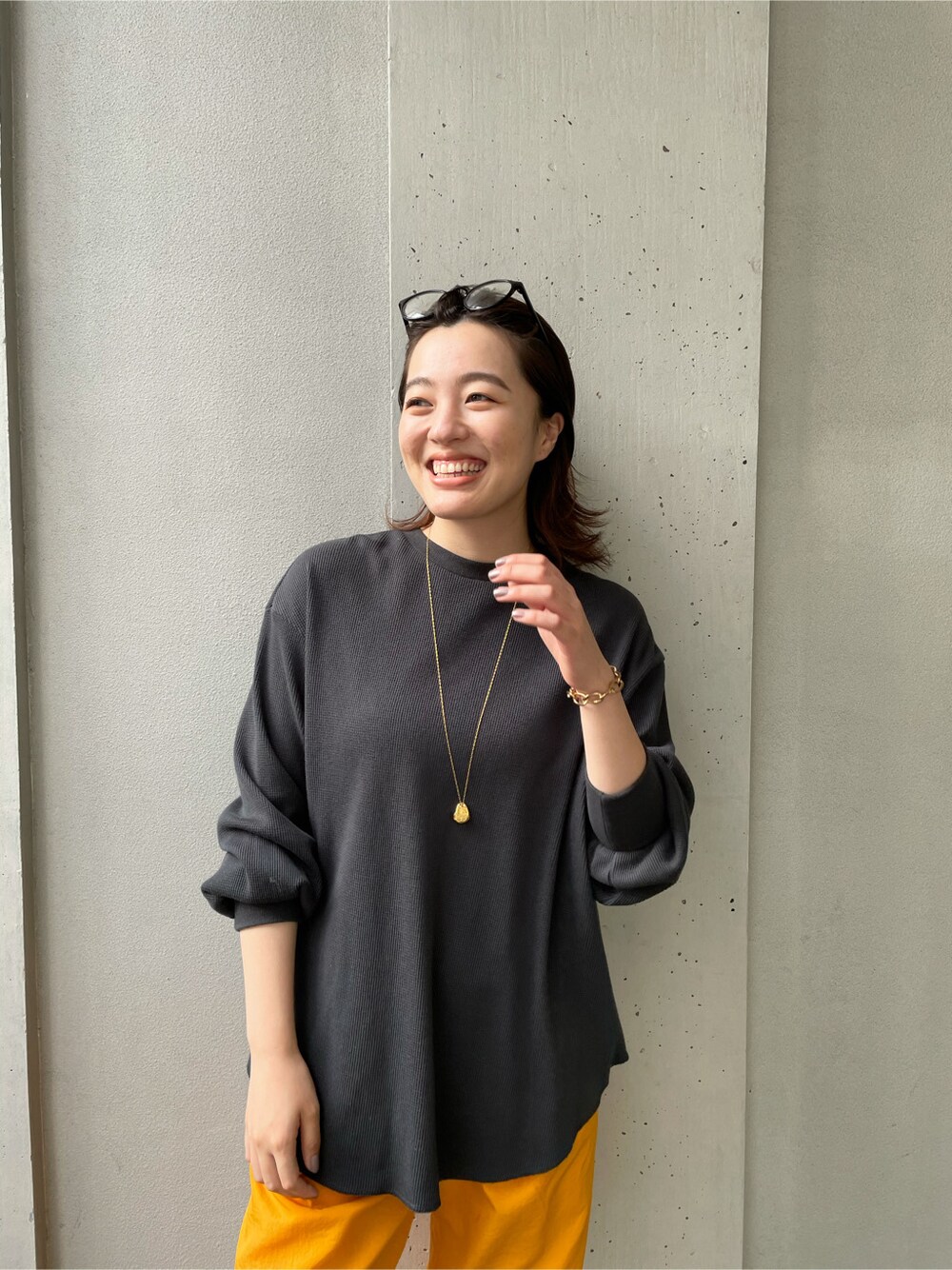 イエロー系のその他パンツ、グレー系のTシャツ/カットソー、ゴールド系のブレスレットを着用したレディースの春コーディネートの3枚目の写真