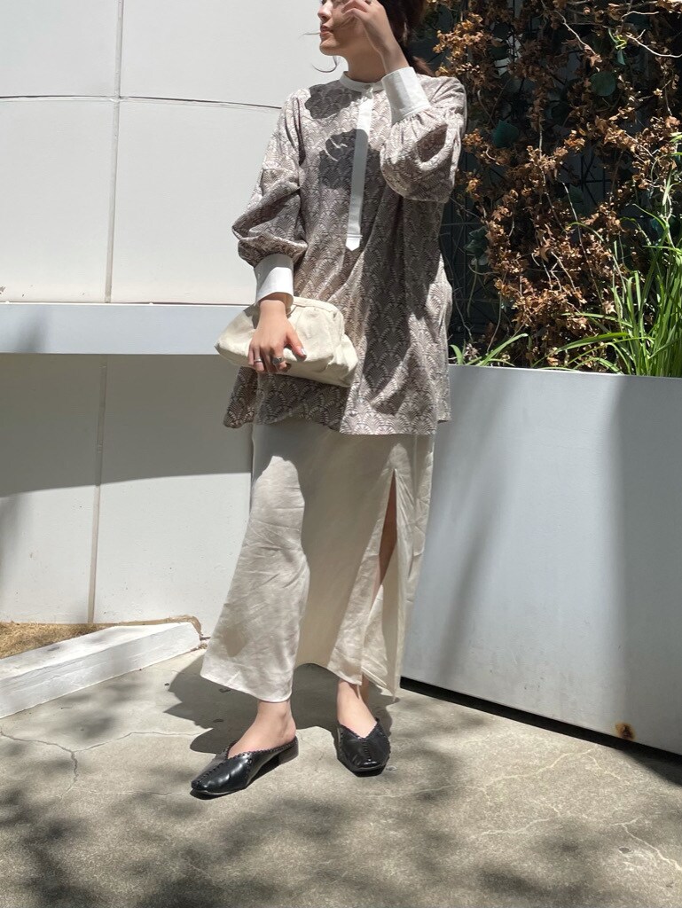 ホワイト系のスカート、ホワイト系のクラッチバッグを着用したレディースの春コーディネートの3枚目の写真