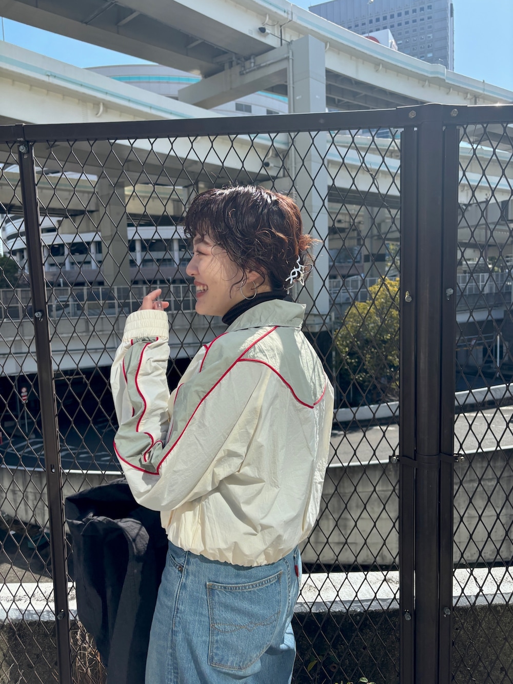 ブラック系のステンカラーコート、ホワイト系のブルゾンを着用したレディースの冬コーディネートの8枚目の写真