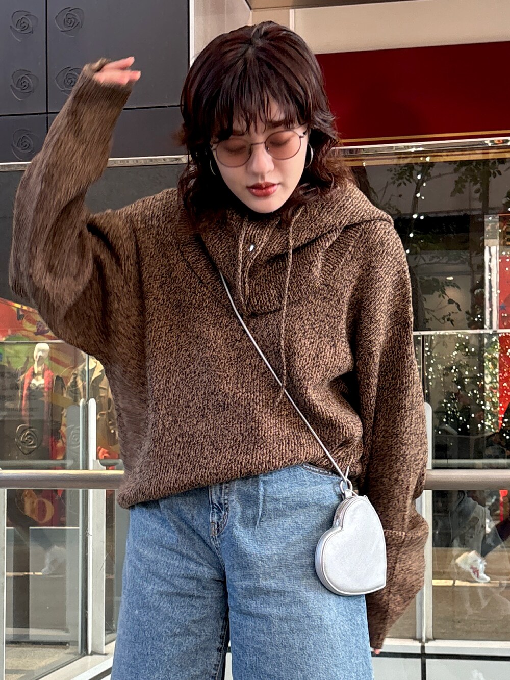 ブラウン系のニット/セーター、ブルー系のデニムパンツ、シルバー系のショルダーバッグを着用したレディースの秋コーディネートの4枚目の写真