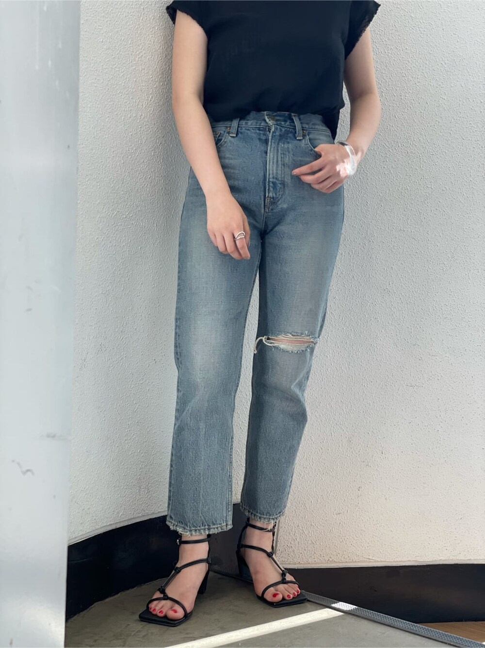 ブラック系のシャツ/ブラウス、ブルー系のデニムパンツ、ブラック系のサンダルを着用したレディースの夏コーディネートの5枚目の写真