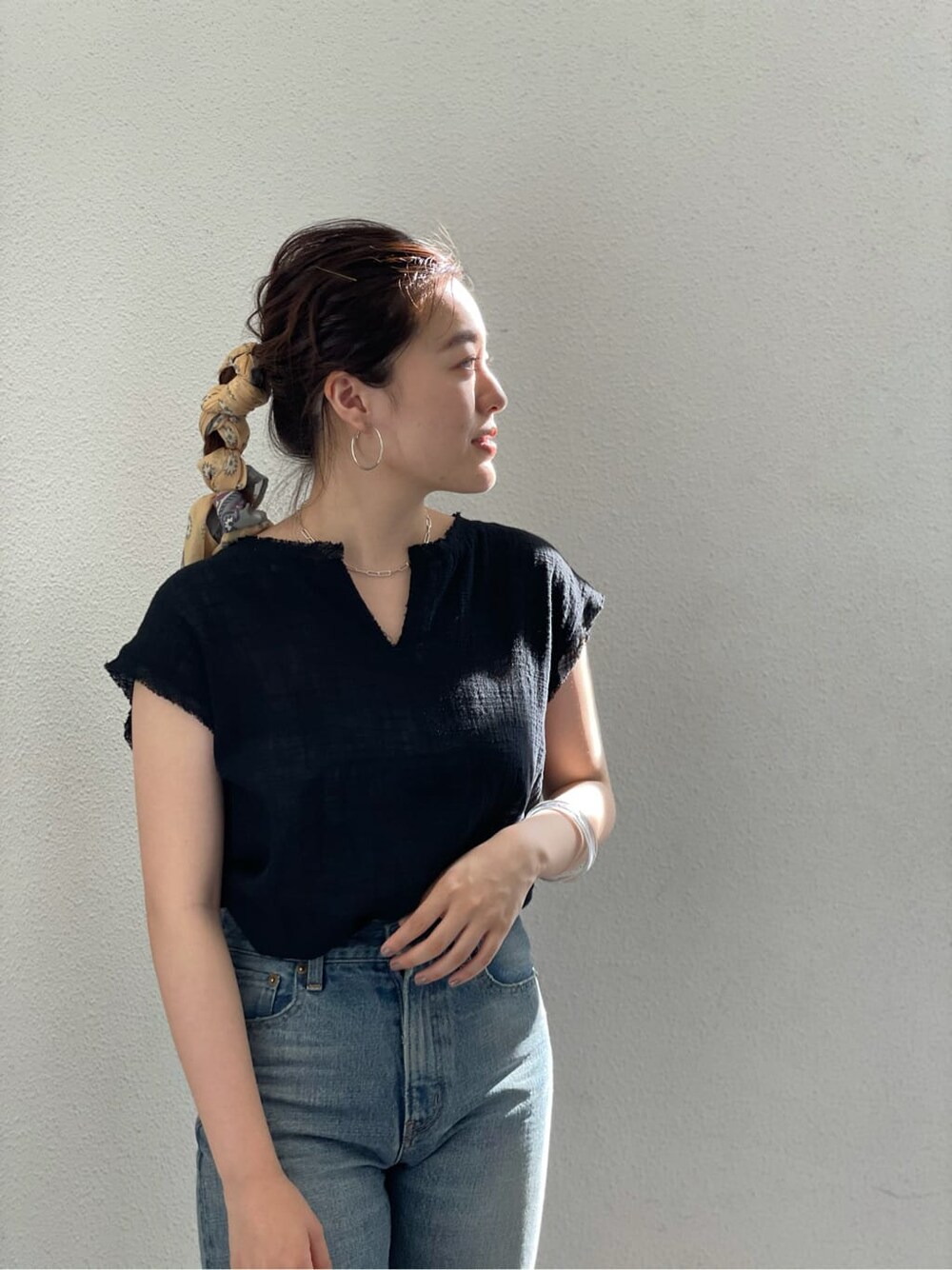 ブラック系のシャツ/ブラウス、ブルー系のデニムパンツ、ブラック系のサンダルを着用したレディースの夏コーディネートの4枚目の写真