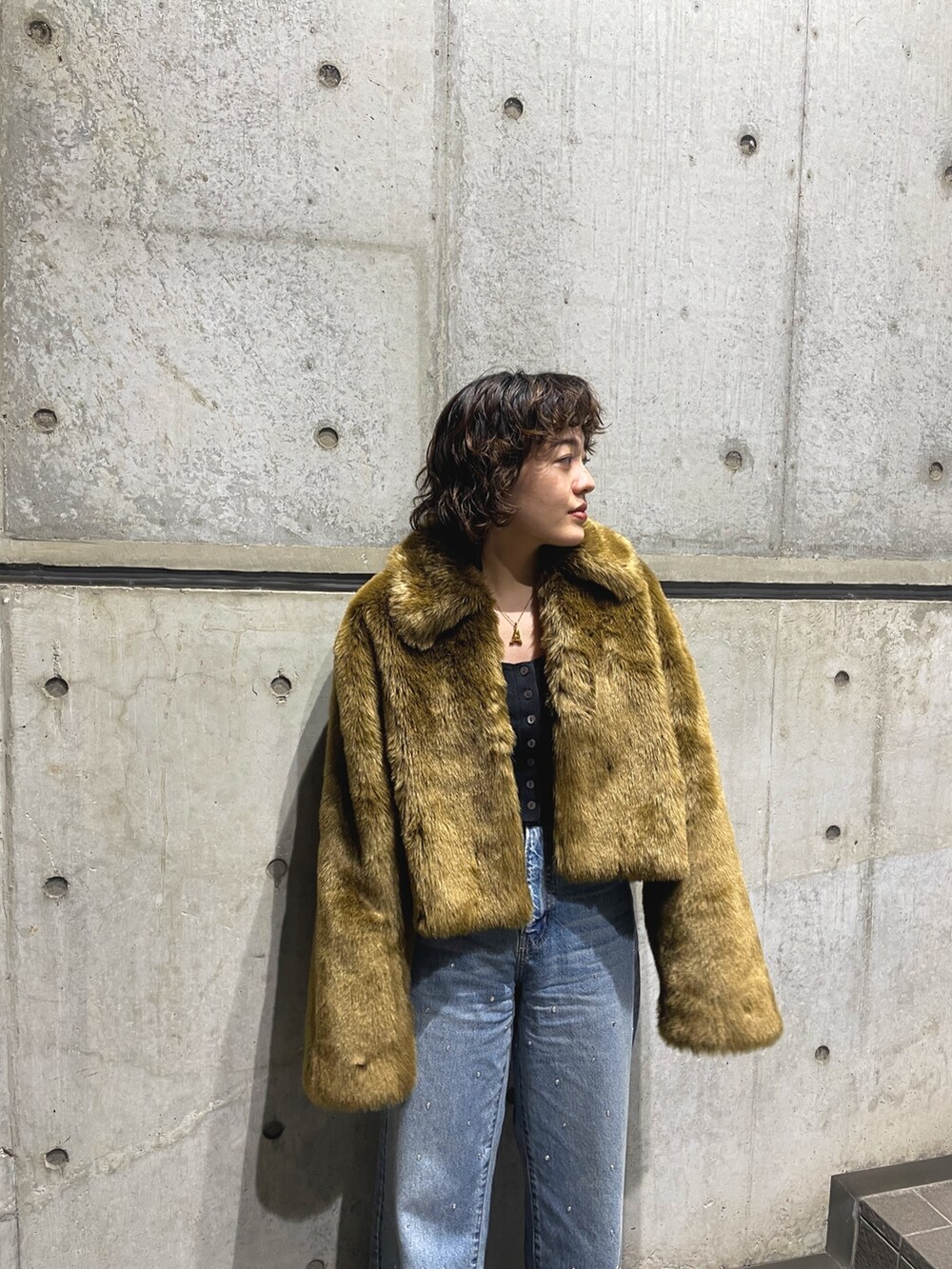 ブラウン系のブルゾン、ブルー系のデニムパンツを着用したレディースの秋コーディネートの4枚目の写真