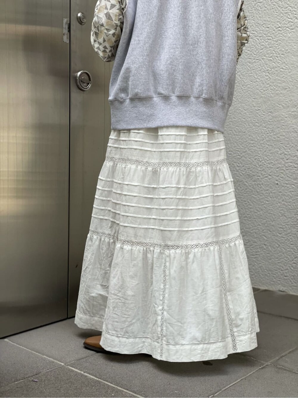 ブラウン系のシャツ/ブラウス、ホワイト系のスカート、ブラウン系のブーツを着用したレディースの夏コーディネートの5枚目の写真
