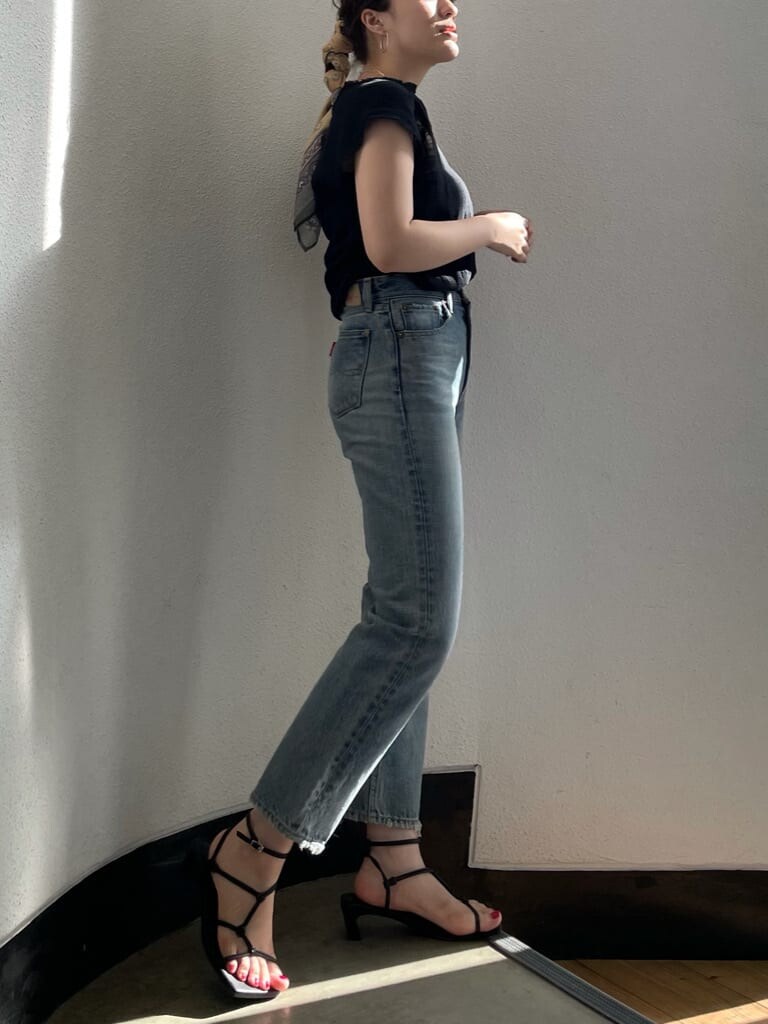 ブラック系のシャツ/ブラウス、ブルー系のデニムパンツ、ブラック系のサンダルを着用したレディースの夏コーディネートの2枚目の写真