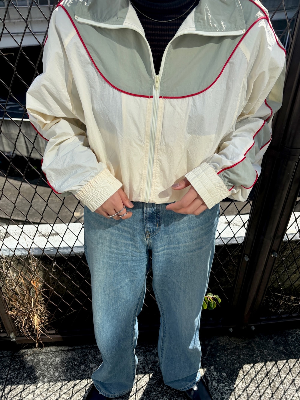 ブラック系のステンカラーコート、ホワイト系のブルゾンを着用したレディースの冬コーディネートの9枚目の写真