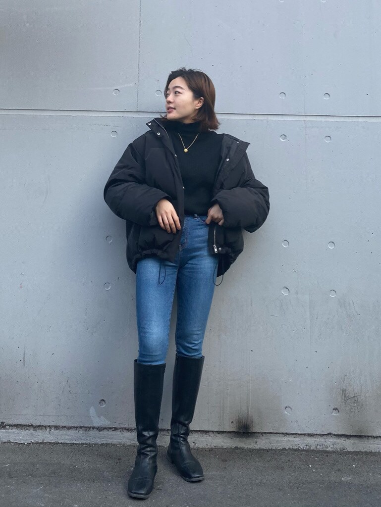 ブルー系のデニムパンツ、ブラック系のダウンジャケット/コートを着用したレディースの冬コーディネートの2枚目の写真