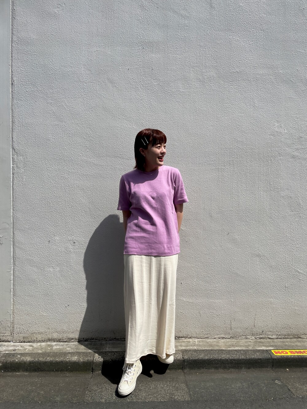 ホワイト系のスカート、パープル系のTシャツ/カットソー、ホワイト系のスニーカーを着用したレディースの春コーディネートの5枚目の写真