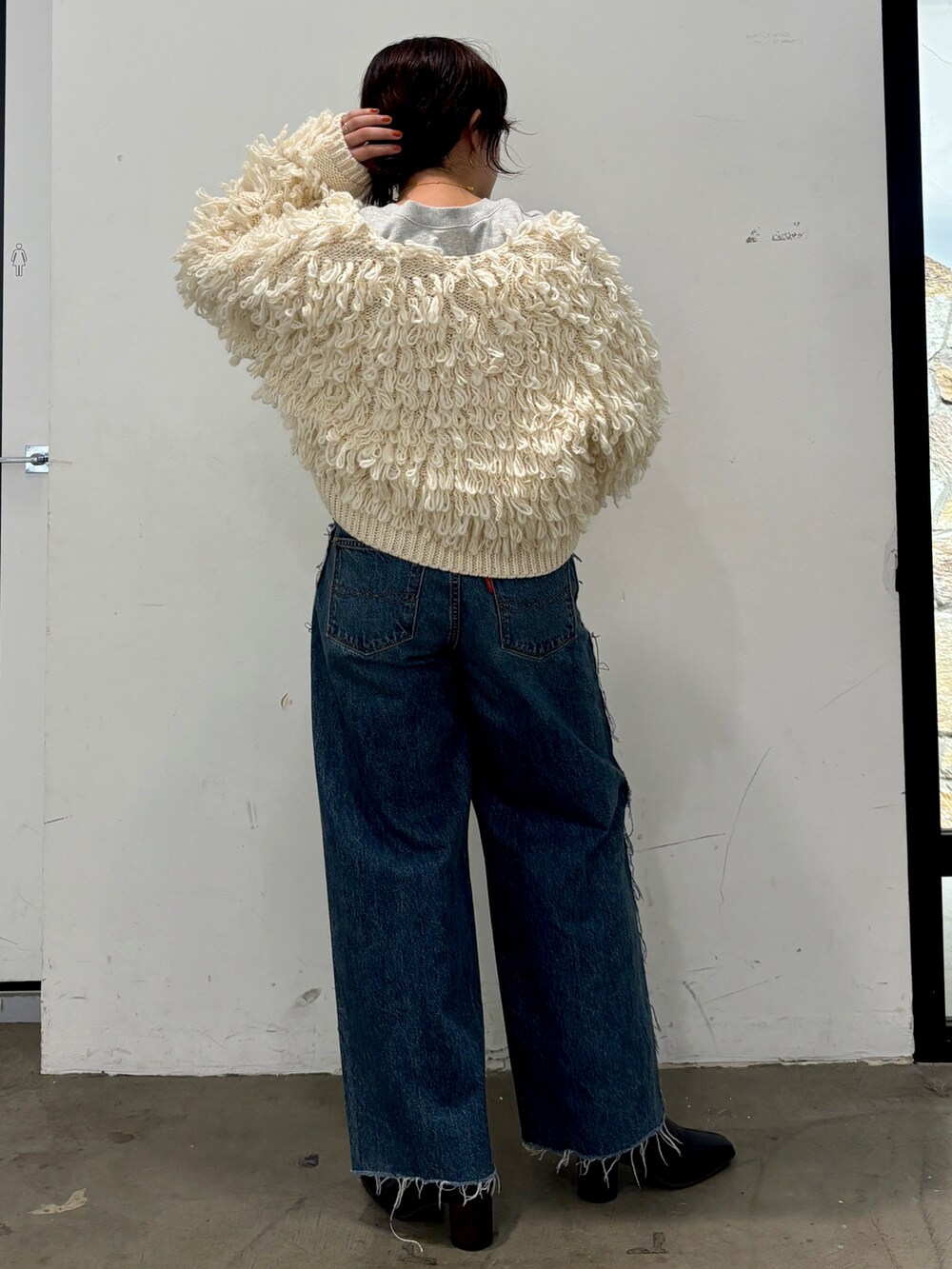 ホワイト系のカーディガン/ボレロ、ブルー系のデニムパンツ、グレー系のスウェットを着用したレディースの冬コーディネートの3枚目の写真