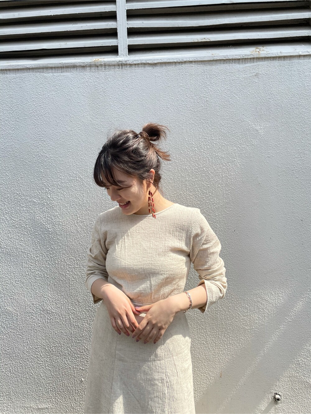 ホワイト系のワンピース、ホワイト系のタンクトップ、レッド系のピアス（両耳用）を着用したレディースの春コーディネートの4枚目の写真