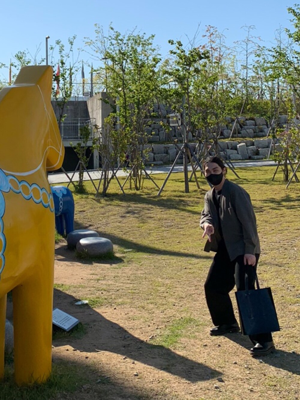 ブラック系のTシャツ/カットソー、グリーン系のカーディガン/ボレロ、ブラック系のスラックスを着用したメンズの春コーディネートの2枚目の写真