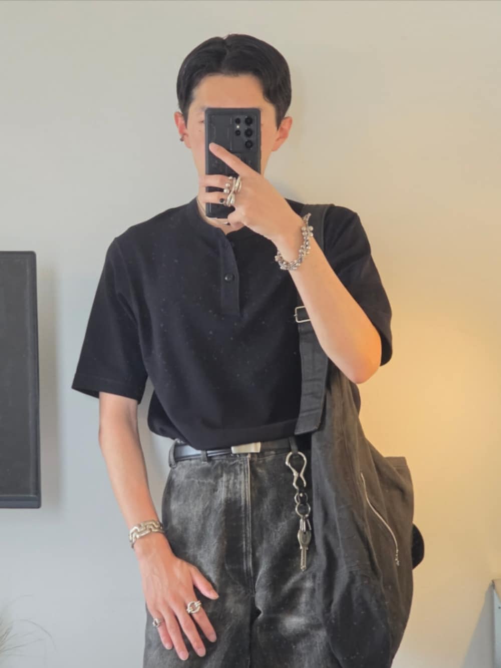 シルバー系のリング、ブラック系のベルト、ブラック系のキーホルダーを着用したメンズの秋コーディネートの2枚目の写真