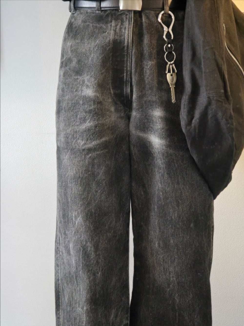 シルバー系のリング、ブラック系のベルト、ブラック系のキーホルダーを着用したメンズの秋コーディネートの3枚目の写真