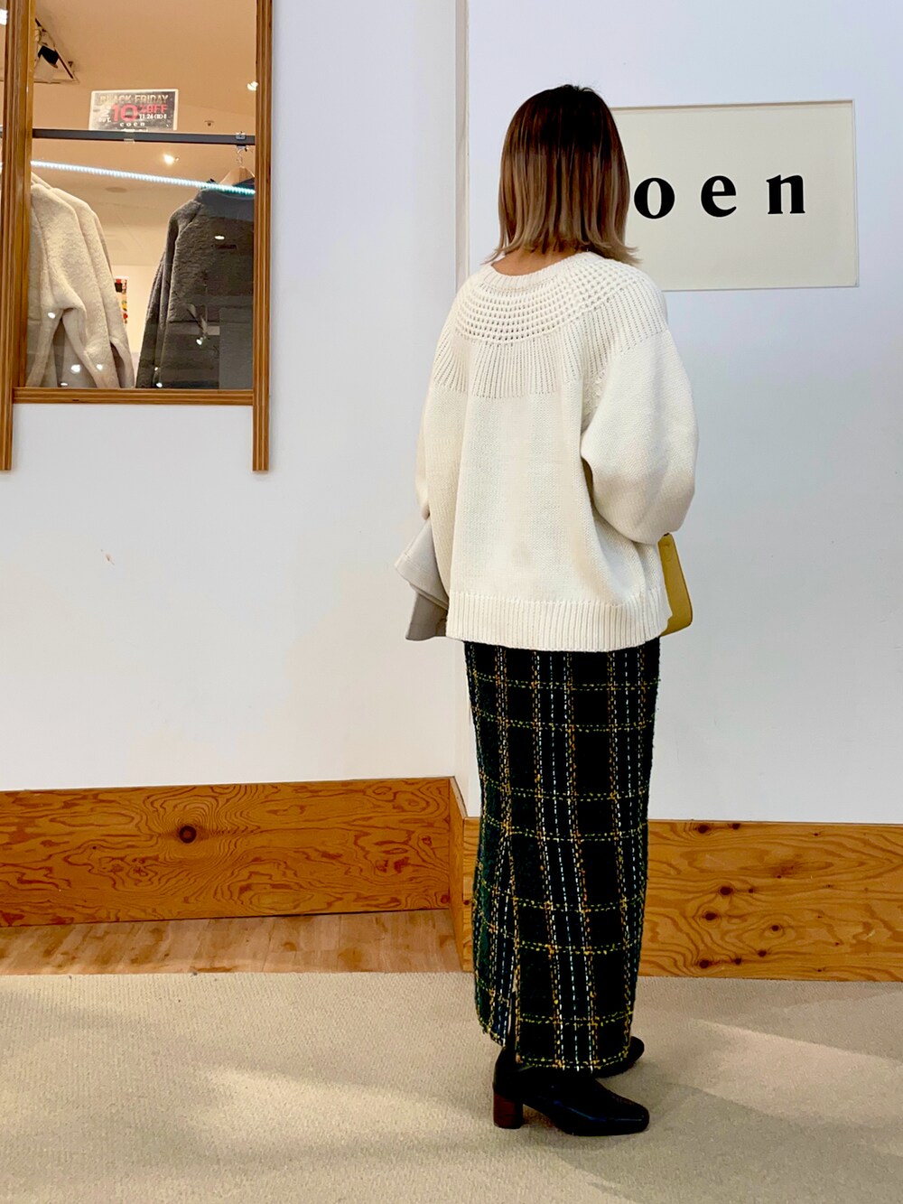 ホワイト系のニット/セーター、グリーン系のスカート、ブラック系のシューズを着用したレディースの冬コーディネートの2枚目の写真