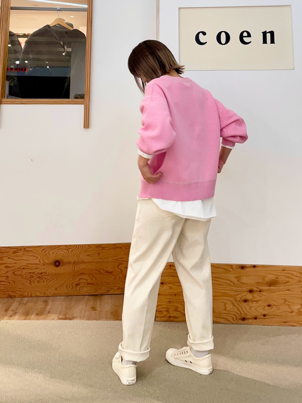 ピンク系のニット/セーター、ホワイト系のチノパンツ、ホワイト系のスリッポンを着用したレディースの冬コーディネートの2枚目の写真