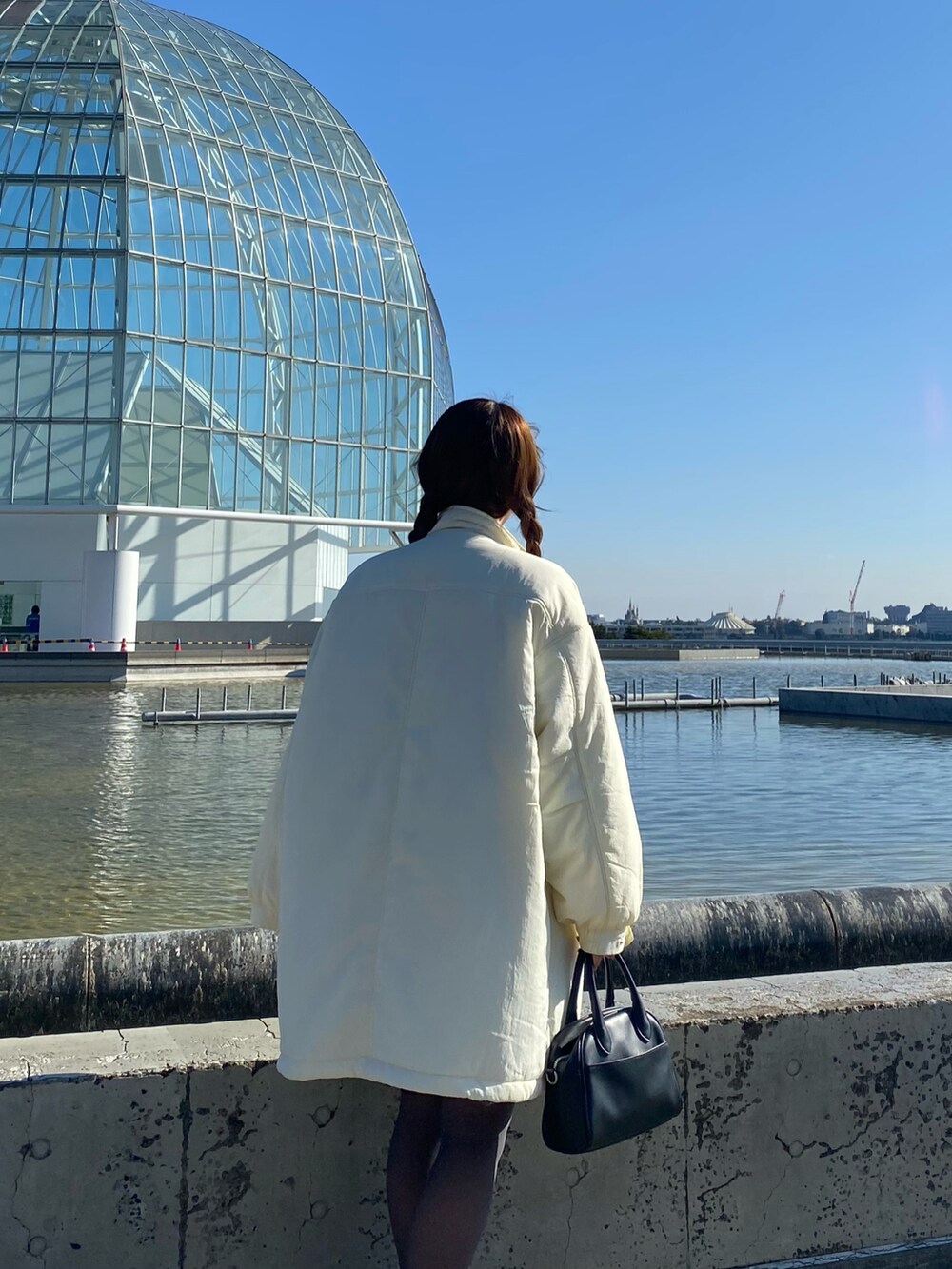 ホワイト系のその他アウター、その他のチュニック、ブラック系のその他パンツを着用したレディースの冬コーディネートの2枚目の写真