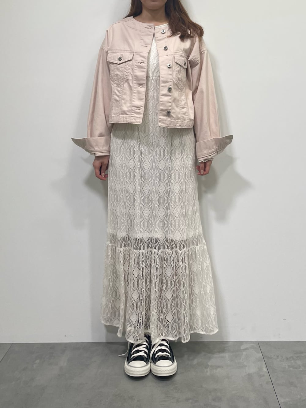 ピンク系のブルゾン、ホワイト系のワンピース、ブラック系のスニーカーを着用したレディースの春コーディネートの2枚目の写真