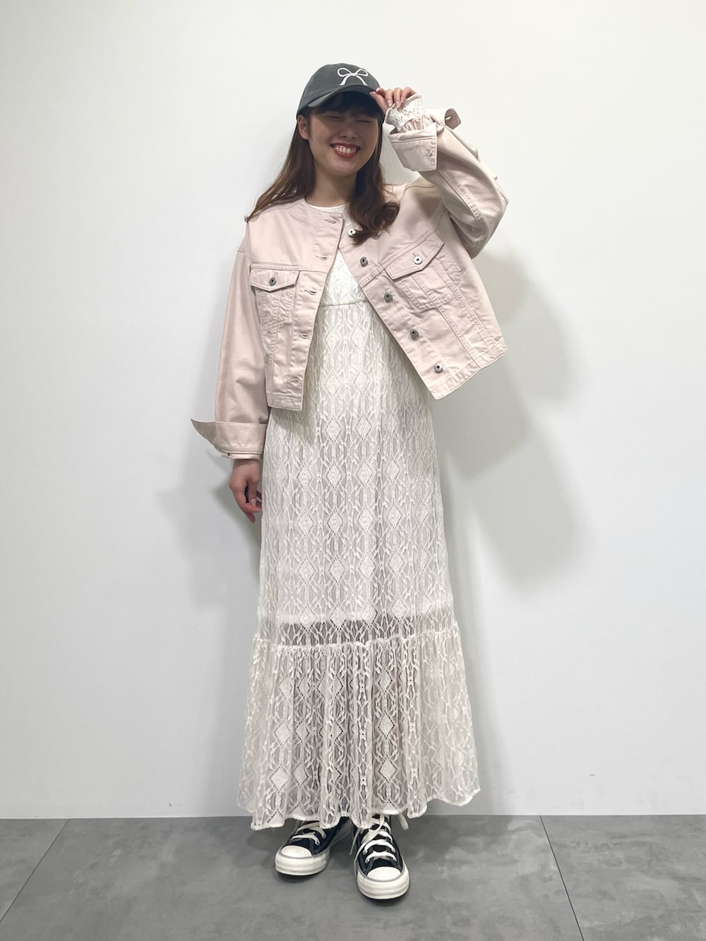 ピンク系のブルゾン、ホワイト系のワンピース、ブラック系のスニーカーを着用したレディースの春コーディネートの4枚目の写真