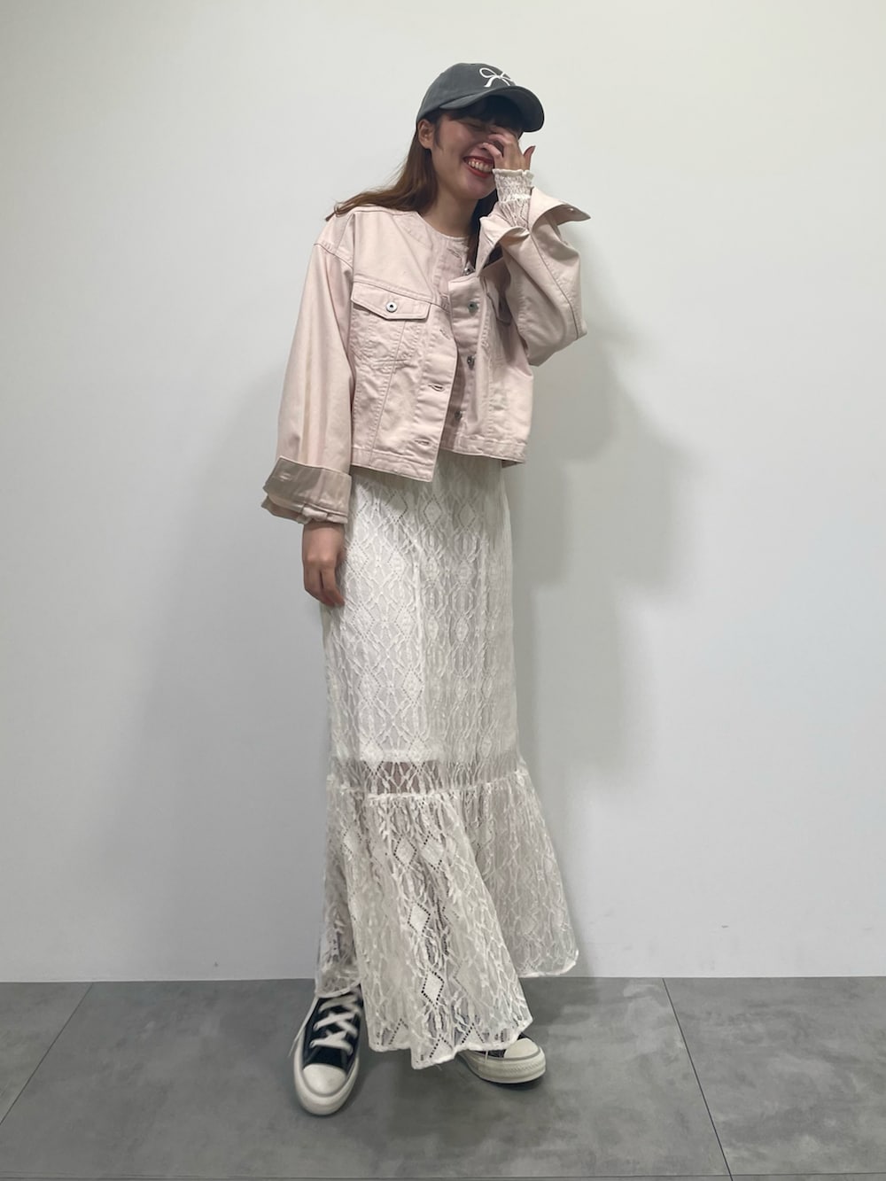 ピンク系のブルゾン、ホワイト系のワンピース、ブラック系のスニーカーを着用したレディースの春コーディネートの3枚目の写真