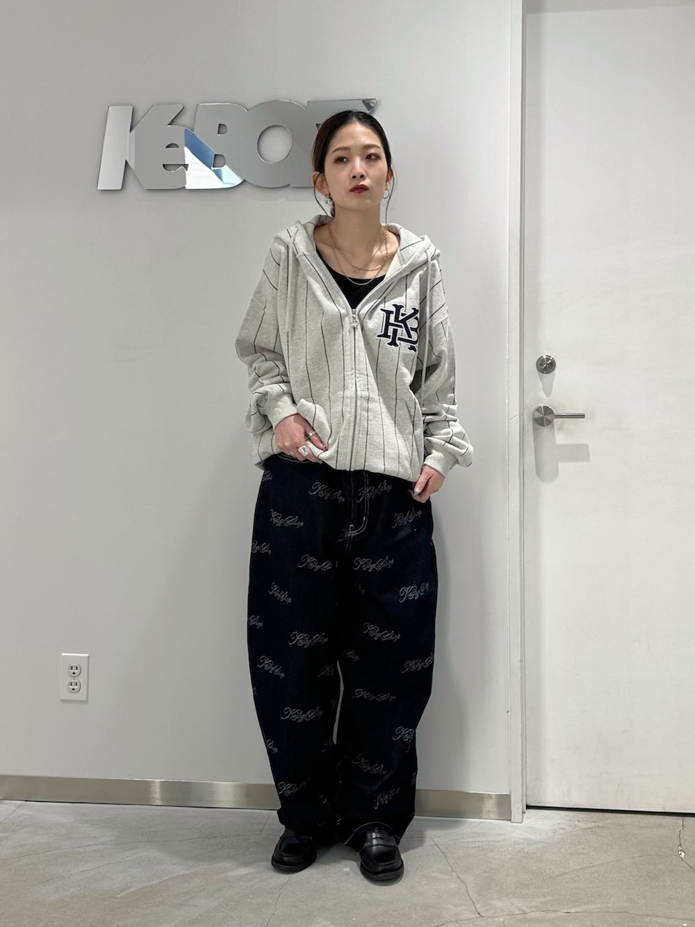 グレー系のパーカー、ブルー系のデニムパンツを着用したレディースの冬コーディネートの2枚目の写真