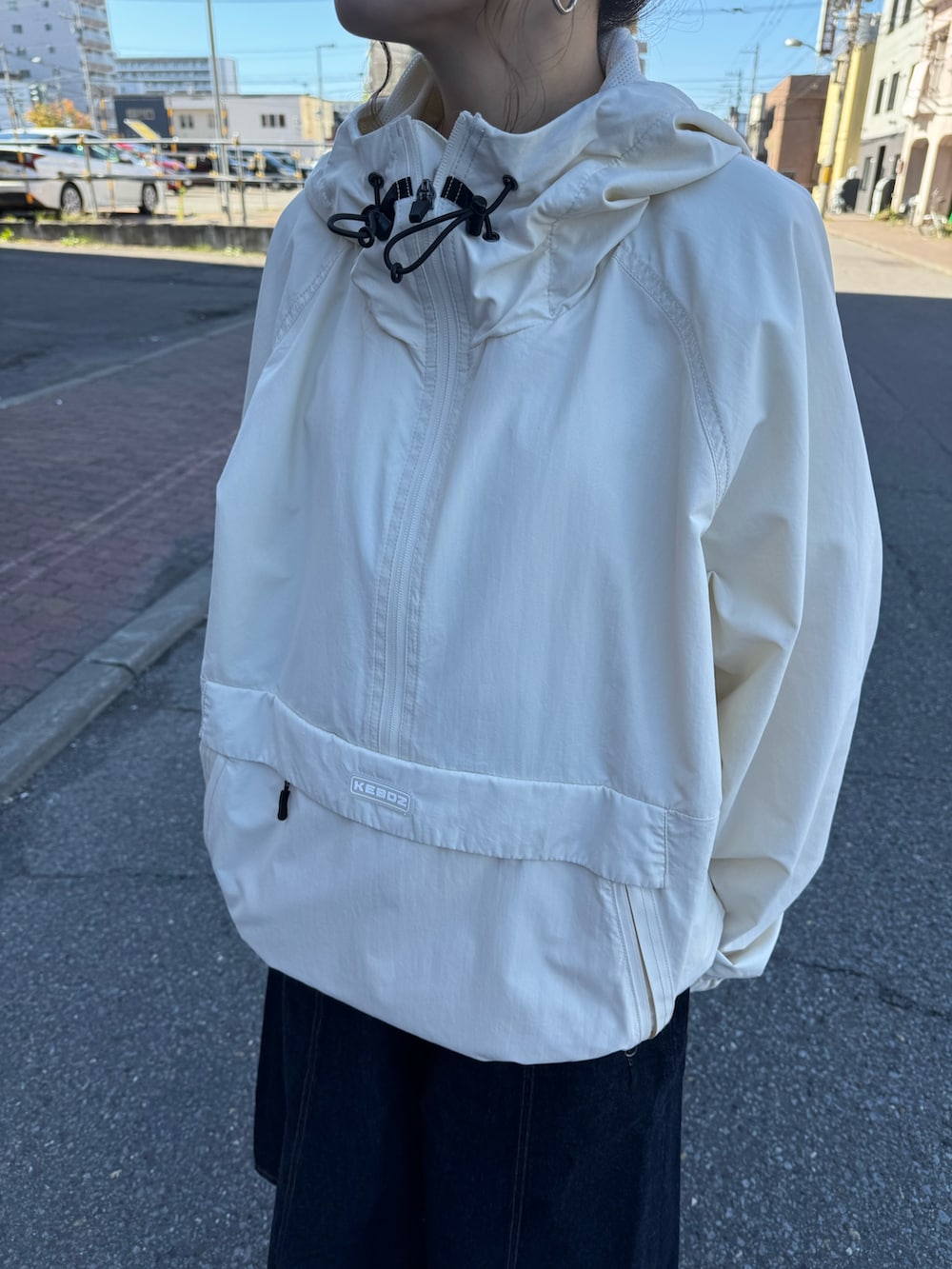 ホワイト系のパーカー、ブルー系のデニムスカートを着用したレディースの秋コーディネートの4枚目の写真