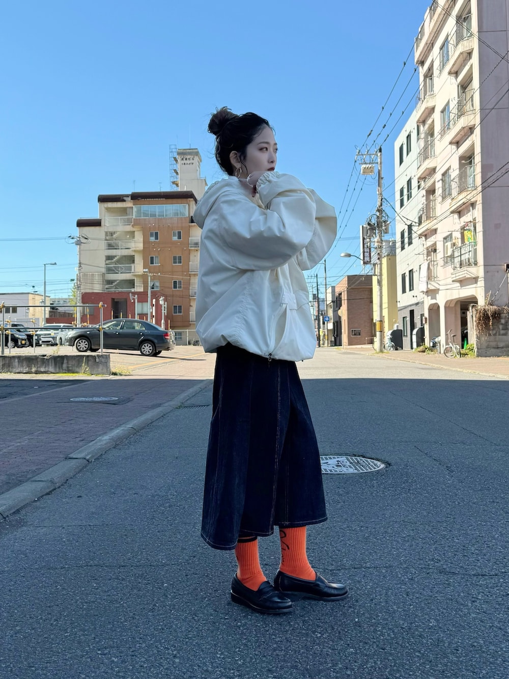 ホワイト系のパーカー、ブルー系のデニムスカートを着用したレディースの秋コーディネートの2枚目の写真