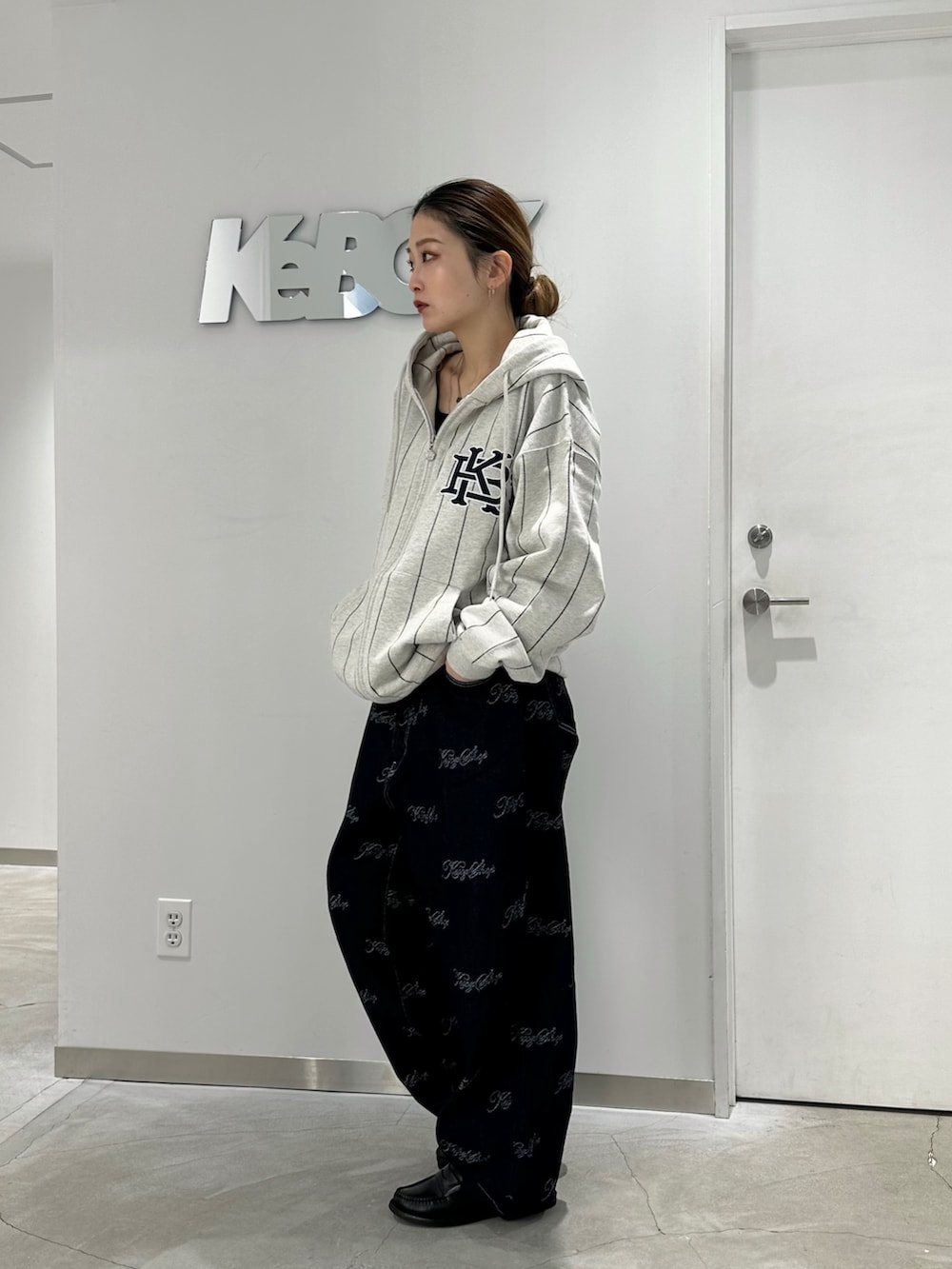 グレー系のパーカー、ブルー系のデニムパンツを着用したレディースの冬コーディネートの3枚目の写真