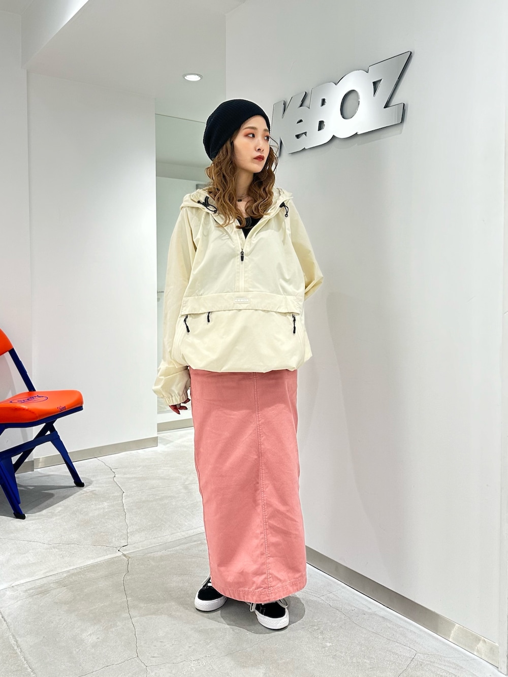 ホワイト系のパーカー、ピンク系のスカートを着用したレディースの秋コーディネートの2枚目の写真