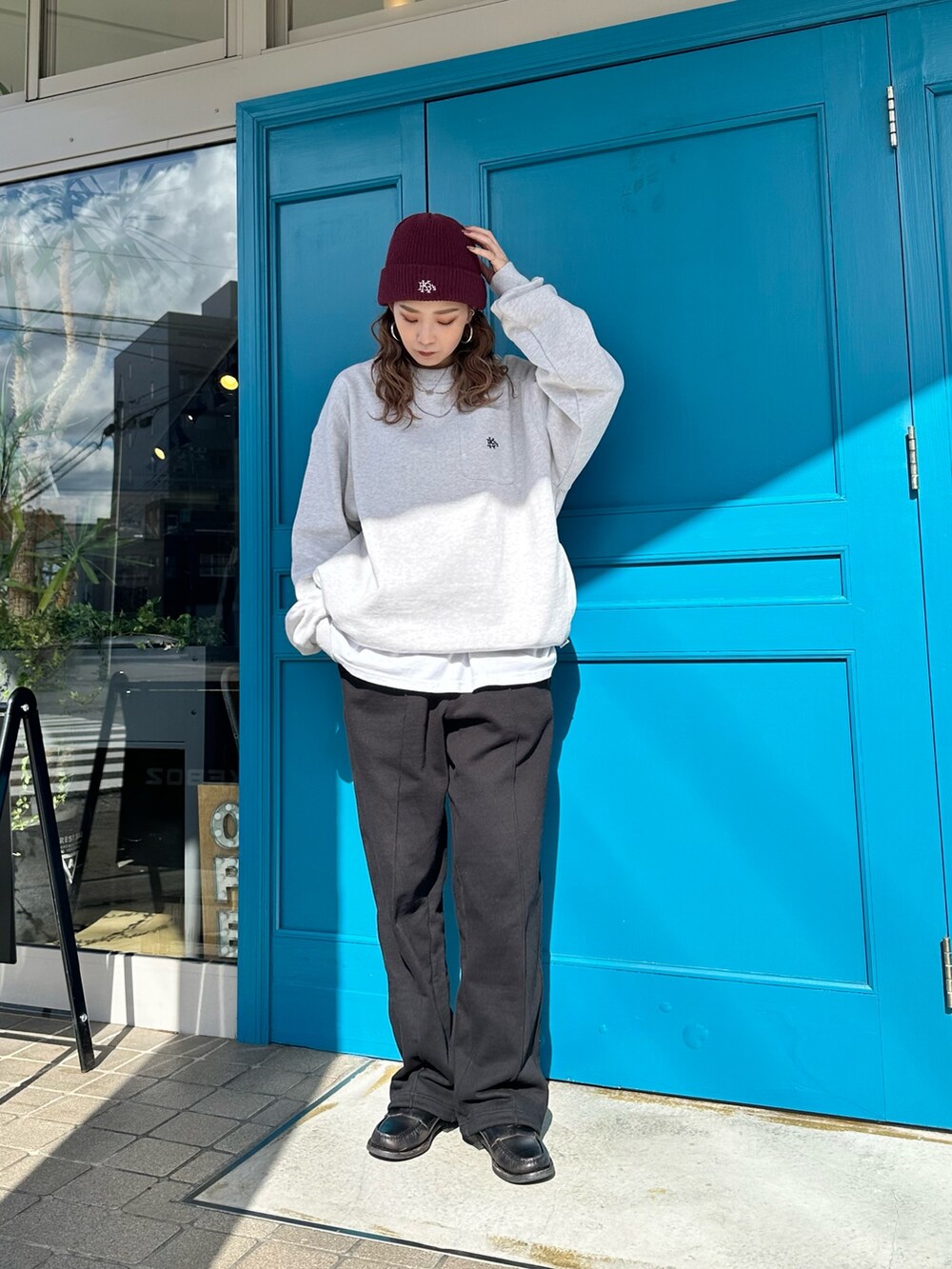 グレー系のスウェット、ブラック系のスウェットパンツ、レッド系のニットキャップ/ビーニーを着用したレディースの秋コーディネートの3枚目の写真