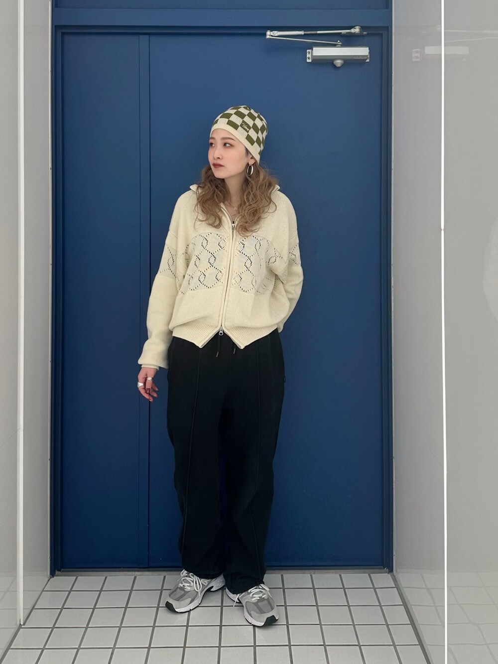 ホワイト系のブルゾン、ブラック系のスウェットパンツ、ベージュ系のニットキャップ/ビーニーを着用したレディースの冬コーディネートの2枚目の写真