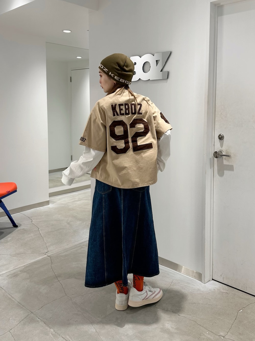 ベージュ系のシャツ/ブラウス、ホワイト系のTシャツ/カットソー、ブルー系のデニムスカートを着用したレディースの秋コーディネートの2枚目の写真