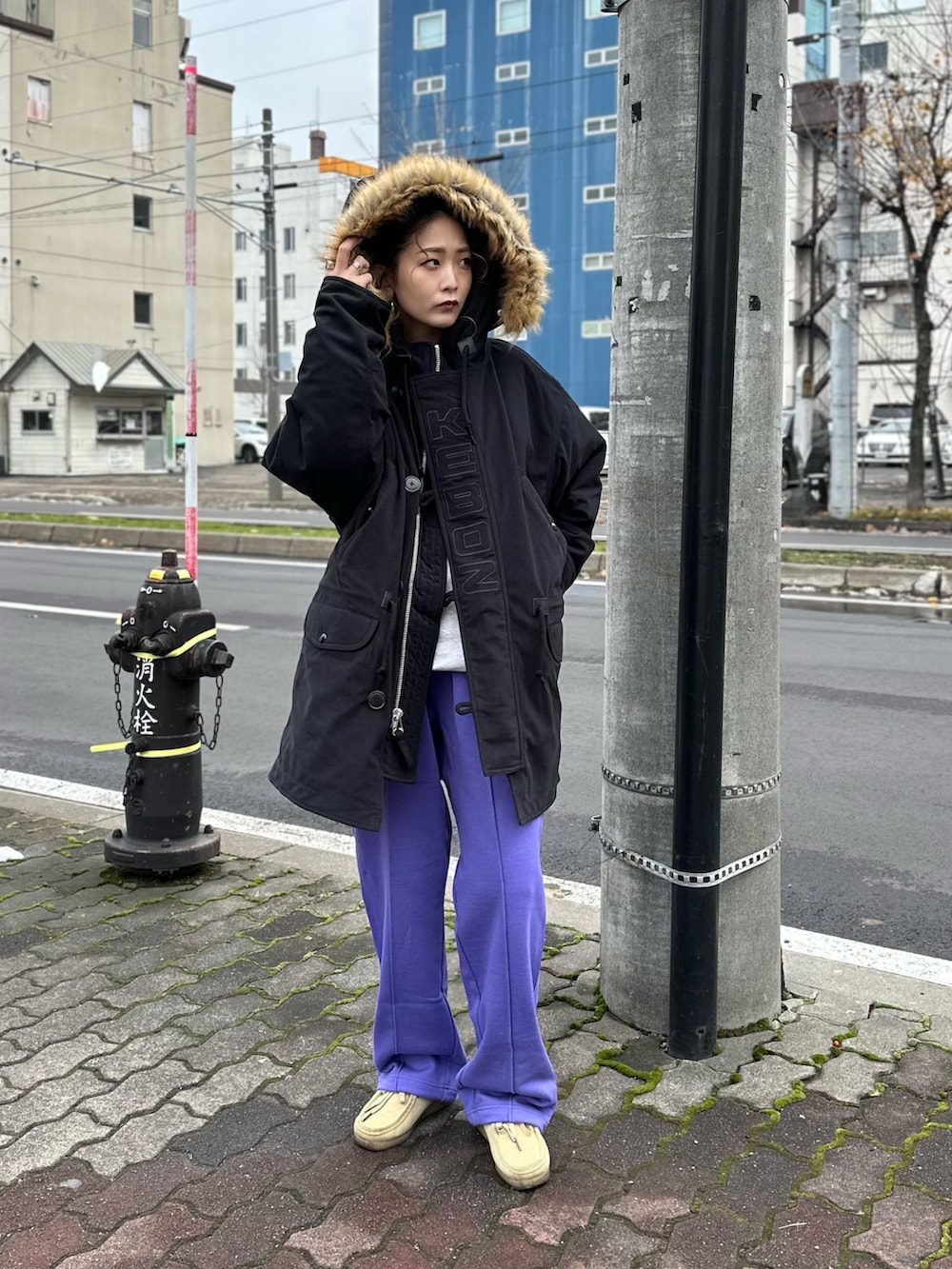 パープル系のスウェットパンツ、ブラック系のミリタリージャケットを着用したレディースの冬コーディネートの2枚目の写真