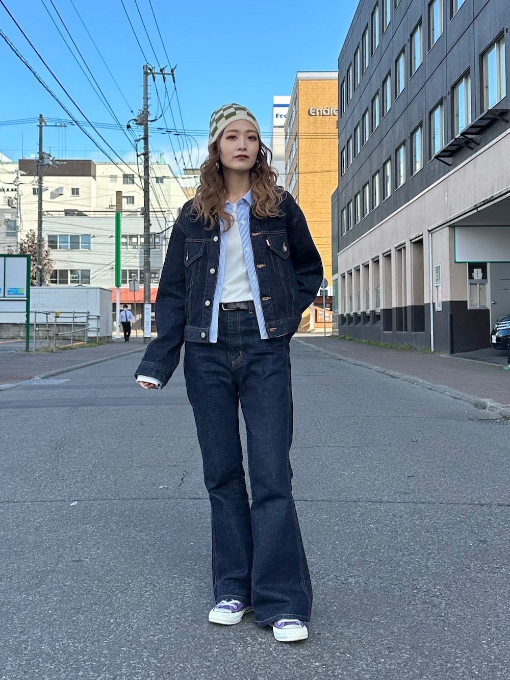 ブルー系のデニムパンツ、ホワイト系のTシャツ/カットソー、ベージュ系のニットキャップ/ビーニーを着用したレディースの秋コーディネートの3枚目の写真