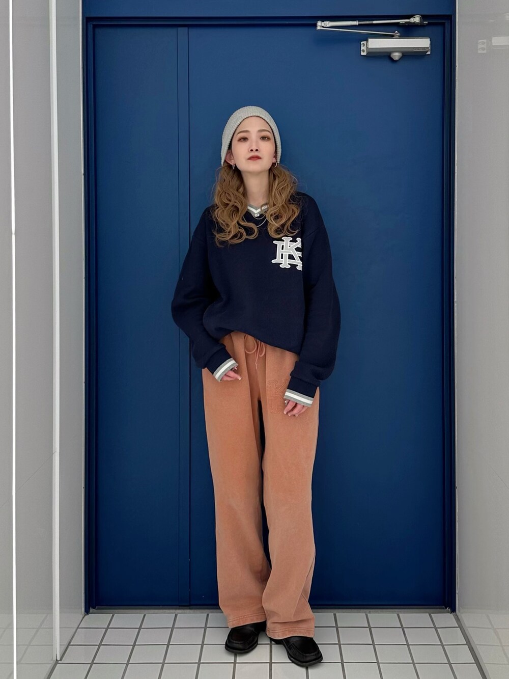 ブルー系のニット/セーター、ブラウン系のスウェットパンツを着用したレディースの冬コーディネートの2枚目の写真