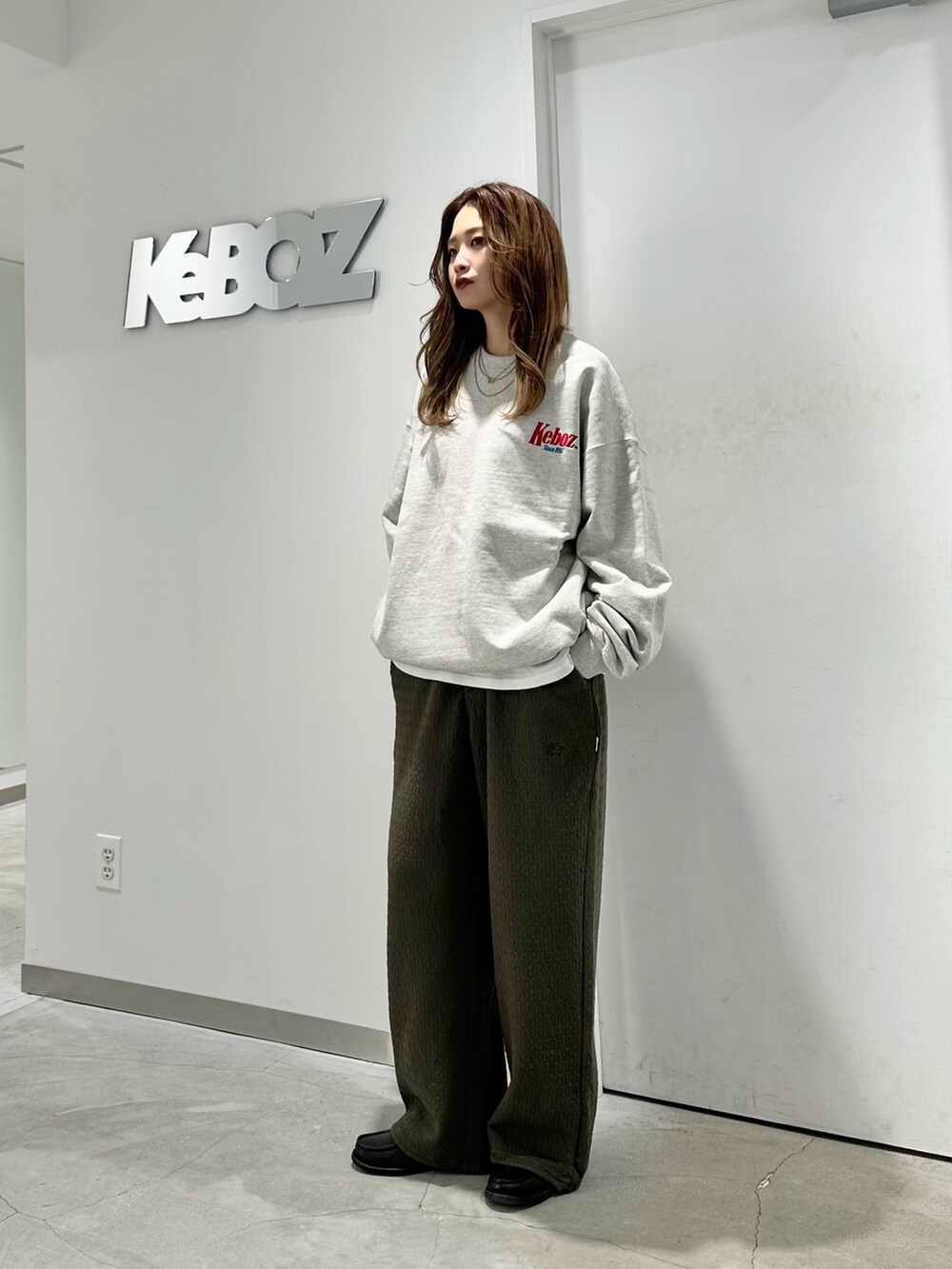 グレー系のスウェット、グリーン系のその他パンツを着用したレディースの秋コーディネートの2枚目の写真