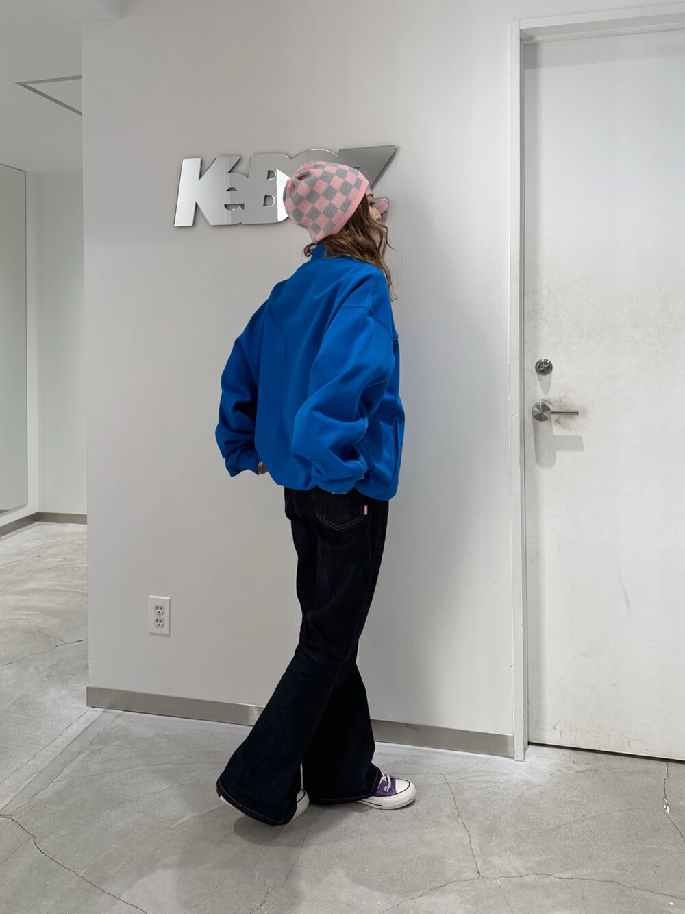 ブルー系のスタジャン、ブルー系のデニムパンツ、ピンク系のニットキャップ/ビーニーを着用したレディースの冬コーディネートの2枚目の写真