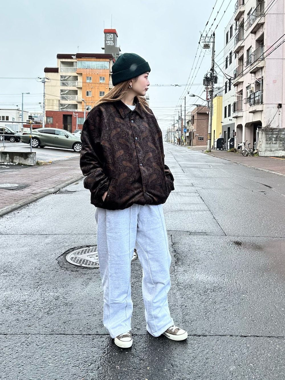 ブラウン系のブルゾン、グレー系のスウェットパンツ、グリーン系のニットキャップ/ビーニーを着用したレディースの冬コーディネートの2枚目の写真