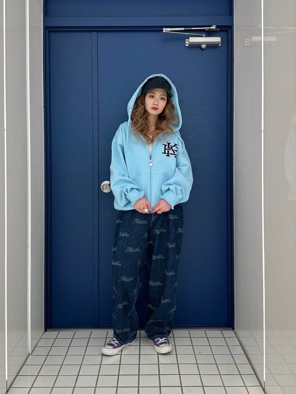 ブルー系のパーカー、ブルー系のデニムパンツを着用したレディースの春コーディネートの2枚目の写真