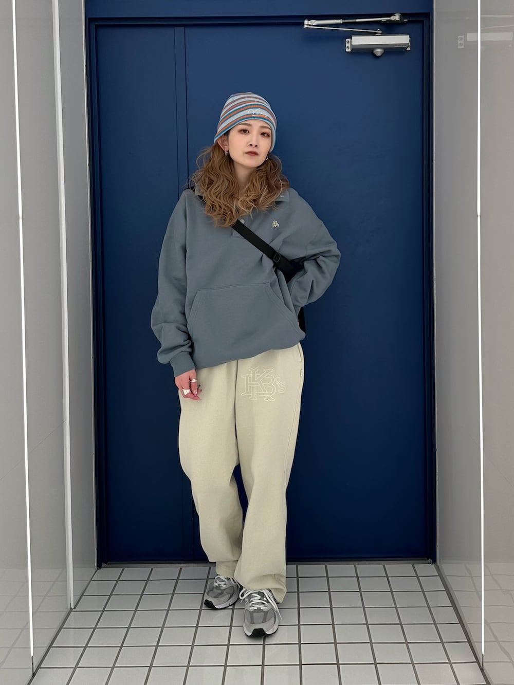 ベージュ系のスウェットパンツ、ブラック系のショルダーバッグ、グレー系のスウェットを着用したレディースの冬コーディネートの2枚目の写真